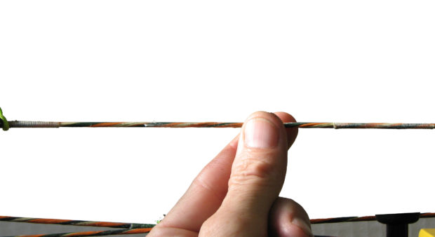 fingers waxing a bow string 