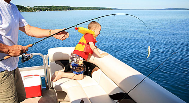 family fishing week - child in a boat with parent fishing 