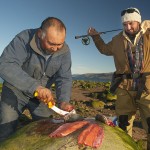 Inuit elder Solomon Awa filleting fish.