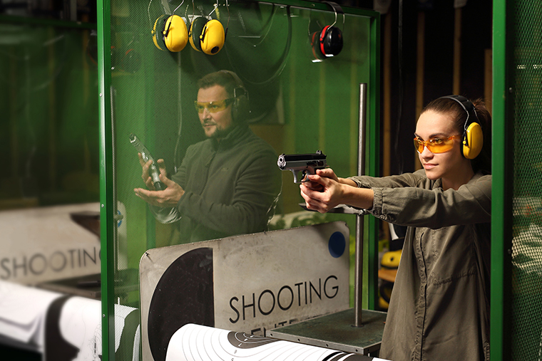 A woman and man at a shooting range practicing their aim.