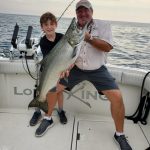 Sean Kanellis, 9, displays a catch while enjoying a day on Lake Ontario with Ontario OUT of DOORS national sales director Stephen Bates, as well as his brother Connor and captain Vito Dattomo of Lord of the Kings King Salmon Charters (not pictured).