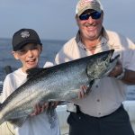 Connor Kanellis, 10, displays a catch while enjoying a day on Lake Ontario with captain Vito Dattomo of Lord of the Kings King Salmon Charters, as well as his brother Sean and Ontario OUT of DOORS national sales director Stephen Bates (not pictured).