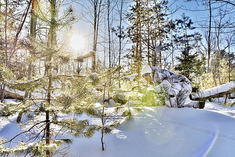 hunter stalking deer in snowy forest