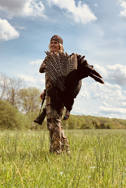 Meghan Patrick with a felled turkey over her shoulder