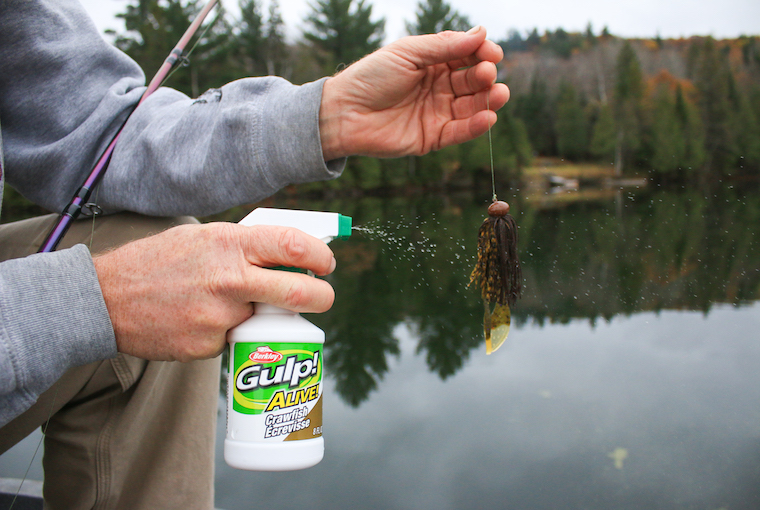 man sprays fish with scent