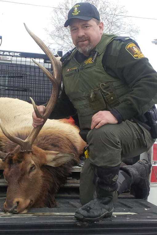 Mike Schenk named CO of the year poses with harvested cervid