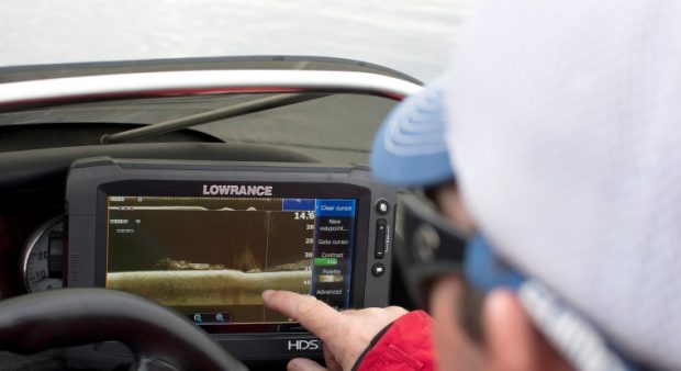 Person pointing at a fish finder screen