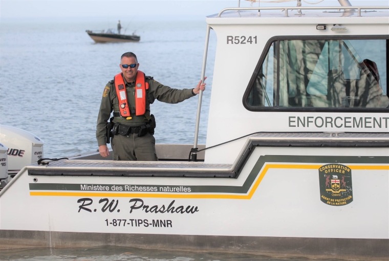 A Conservation Officer standing on a boat