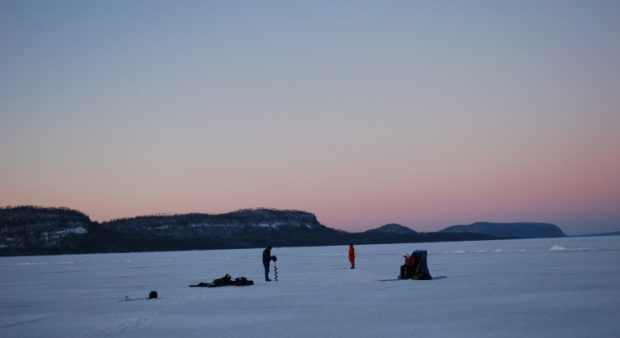 Anglers' silhouettes on the ice