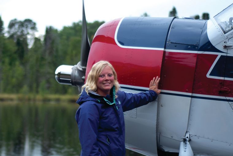 Woman standing in front of a bush plane