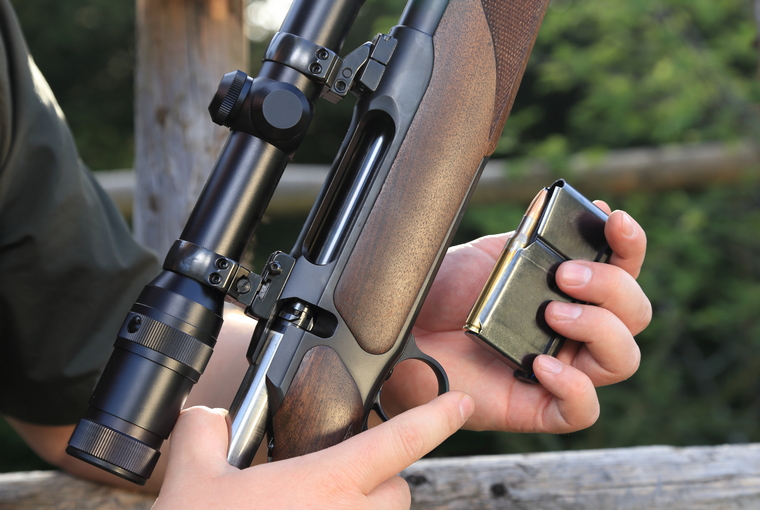 A Hunter loading his hunting rifle gun with magazine