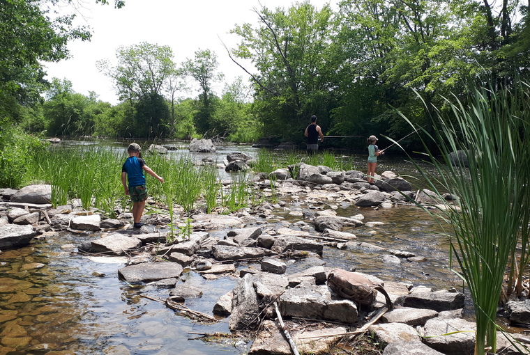 Family fishing on the bank of a rocky river bank