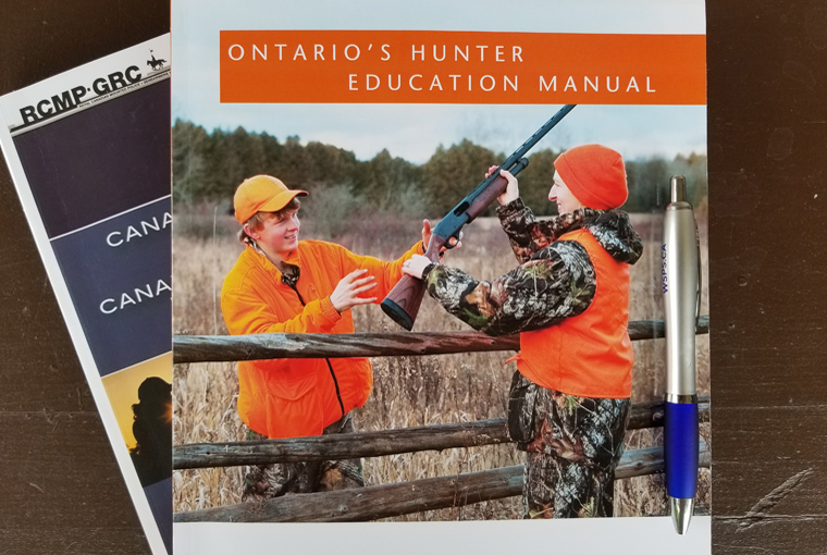 Ontario Hunter Education and Canadian Firearms Course manuals displayed on a desk.