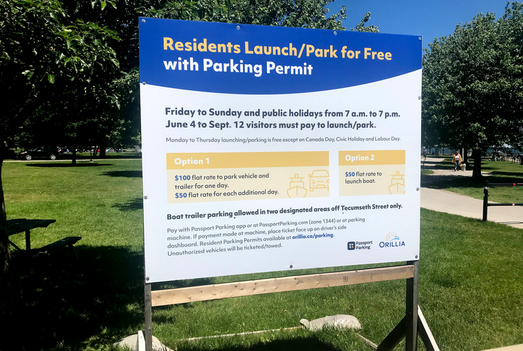 Orillia public sign displaying the new Friday-Sunday parking fees for non-residents.