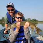 Eleven-year-old River Palhad of Delhi was delighted to pose for her mom, Kelly, after catching her first pike. She was using a yellow and red Hula Popper in the Waterford Ponds after getting a few pointers from her dad, Joe.