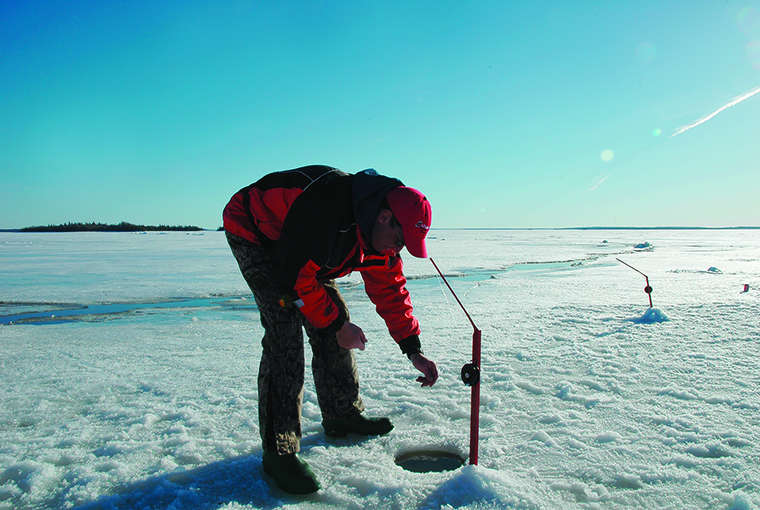 an ice angler checking a tip up