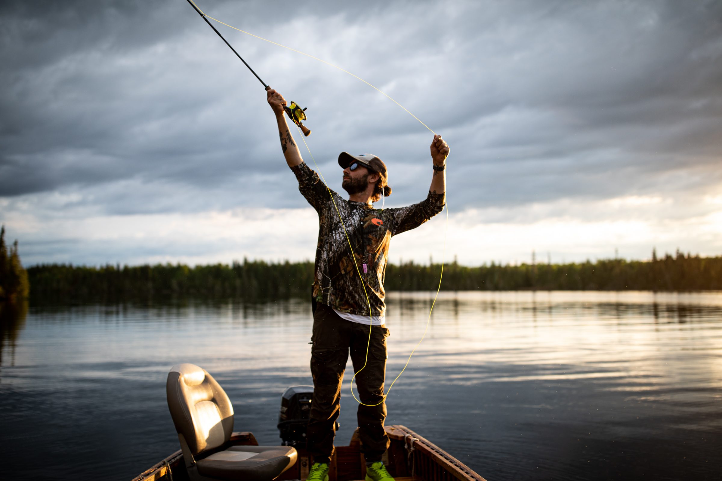 a fly fisher casting on a calm lake