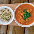 a bowl of butter turkey with a side of coconut rice