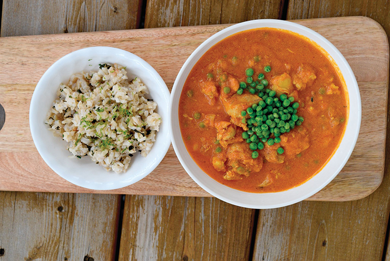 a bowl of butter turkey with a side of coconut rice