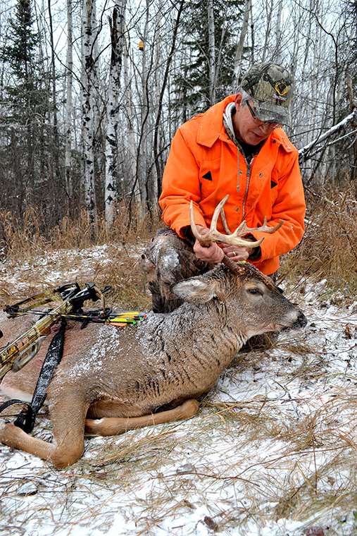 a hunter with a bow-harvested buck