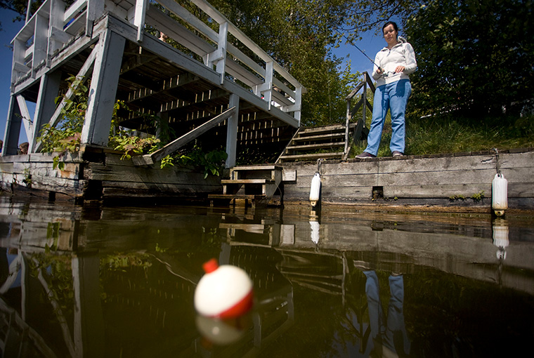 Woman Fishing On Dock