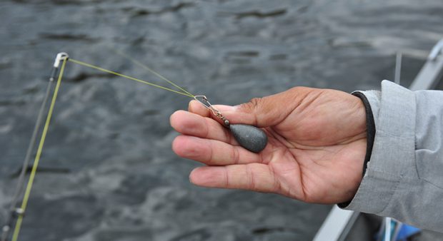 a man pinches a sinker on fishing line