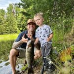 Karson of Thunder Bay with his first fish. This bass almost pulled him into the lake but he was able to reel it in on his own.