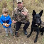 Keenan Levean of Whitney displays a spruce grouse with son, Jensen and brother’s dog, Oliver. Jensen will be the first fourth generation of Levean to hunt in the area.