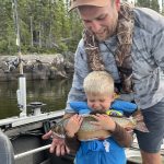 Zach Swain and his three-year-old son Clifford hold a 23-inch spec from their month-long trip in the Nipigon Region.