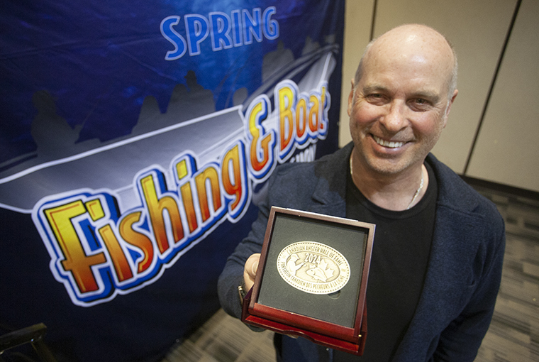 Gord Ellis holds up a token of being named into the Canadian Angler Hall of Fame