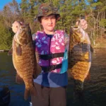 Lee Morton of Sudbury shows his daughter Charlotte’s twin 20-inch pre-spawn smallmouth, which she caught back-to-back in FMZ 10 and revived in an oxygenated livewell prior to release.