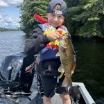 Derek Topham of Paris shares his son Griffin, 6, at the cottage on Kawagama Lake with his first catch of the day.