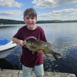 Nick Burd of Peterborough is proud of young Oliver, who caught a four-pound smallmouth using a Ned rig on Wollaston Lake while fishing off the dock at Red Eagle.